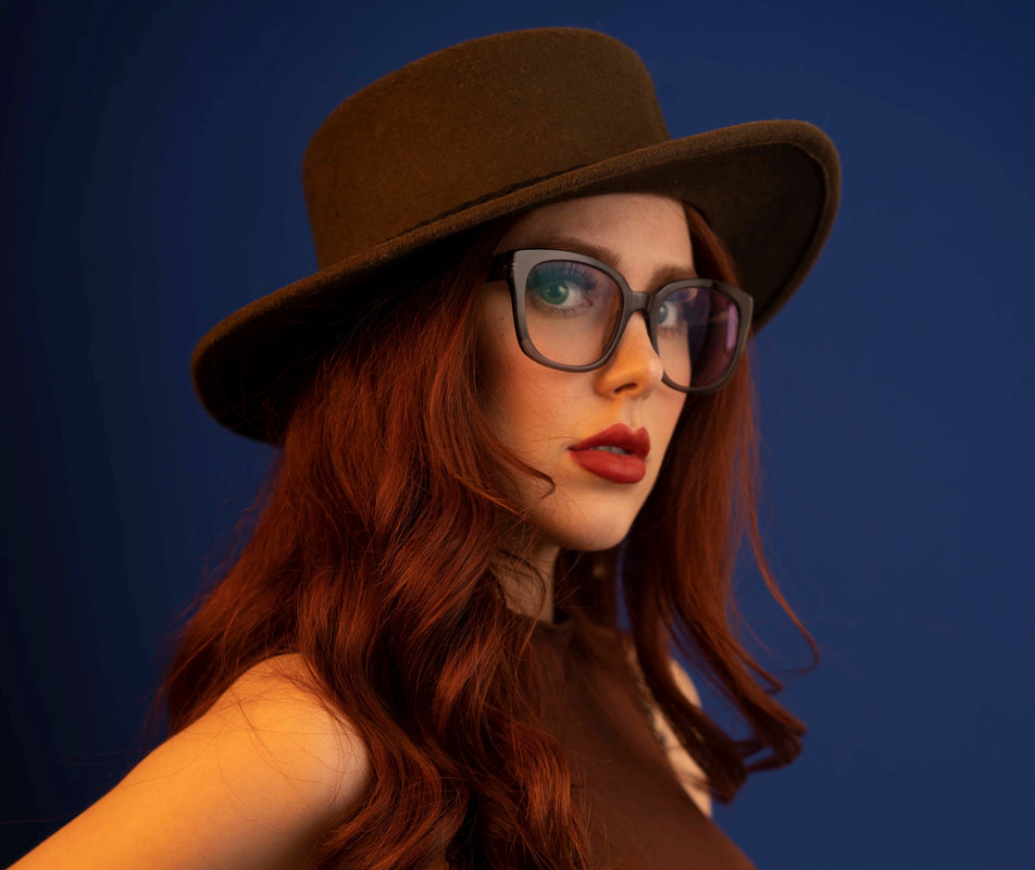 Image of Cheeterz Club eyewear. Photo of square eyeglasses with clear lenses and blue light blocking technology. The frames are wide width and custom laminated colors of black, gray, and silver with gray bottoms. Suitable for round, oval, and heart face shapes. These glasses can be used as reading glasses with blue light glasses.
