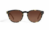 Image of Cheeterz Club eyewear. Photo of round sunglasses with brown tinted lenses. The frames are medium width with green and black camo print. Suitable for square, oval, and oblong shaped face shapes. 
